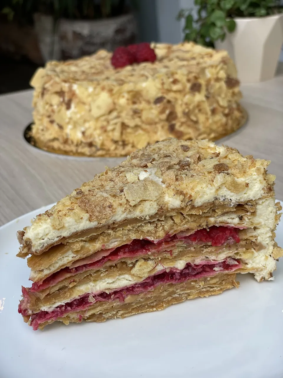 Mil hojas de frambuesa con una porción servida que muestra las capas finas de hojarasca, crema y manjar